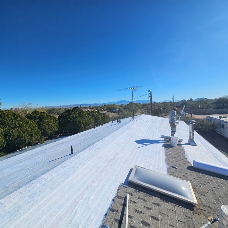 Technician Laying Last Bond Roofing System on Coated Roof